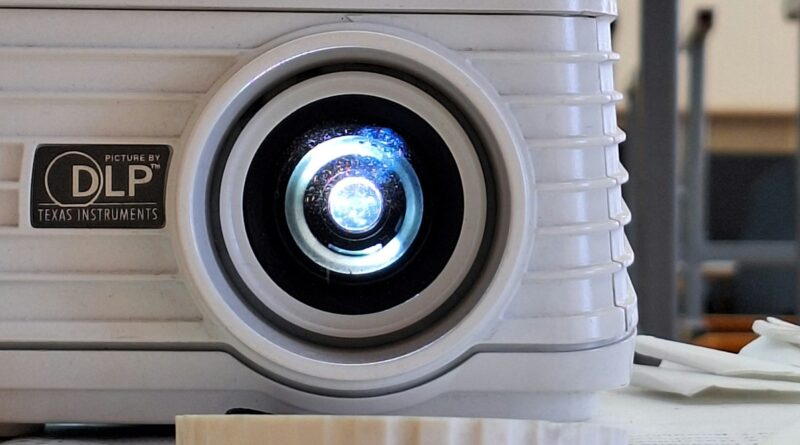 Best portable projector under £200 UK - white projector on wooden table