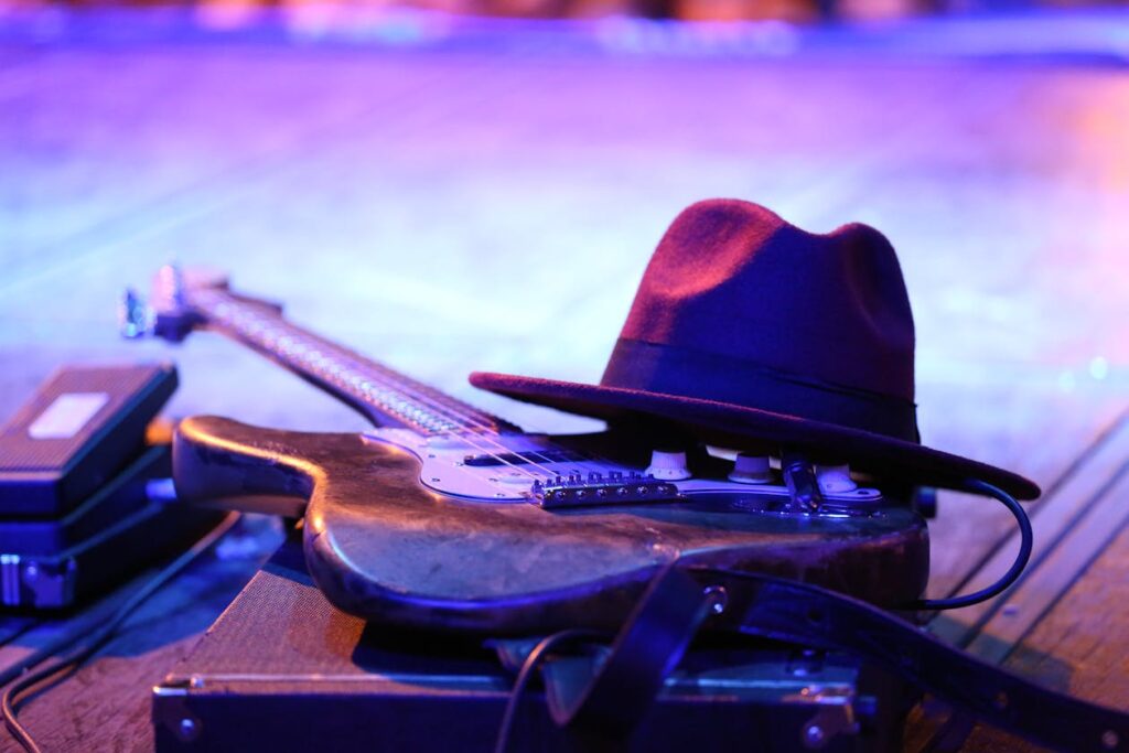 sinners film review blues guitar and hat on stage under purple light evoking 1930s Mississippi atmosphere