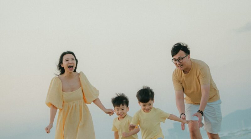 A family running happily on a sandy beach at sunset
