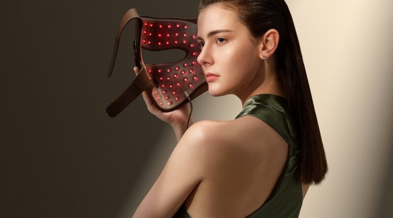 Woman using at-home red light therapy LED device for skin rejuvenation