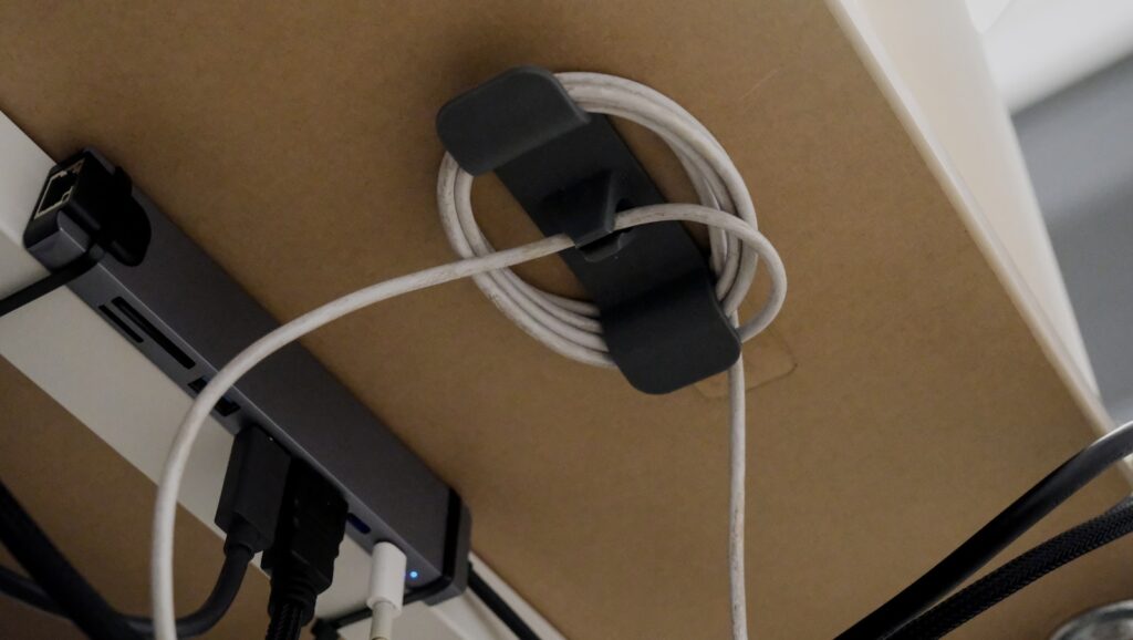 A tidy cable management home office UK setup with an under-desk organiser holding cables.