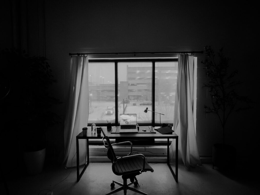 Home office soundproofing UK 2026: a quiet home workspace with curtains, a desk and a chair by a window.