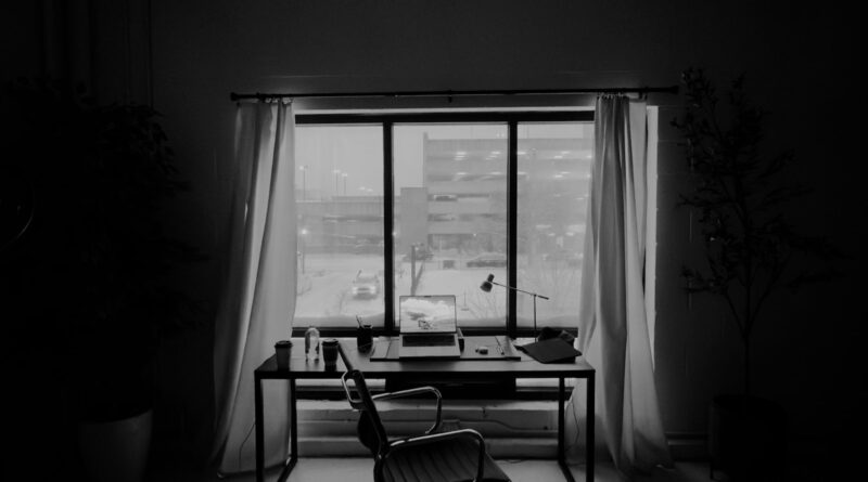 Home office soundproofing UK 2026: a quiet home workspace with curtains, a desk and a chair by a window.