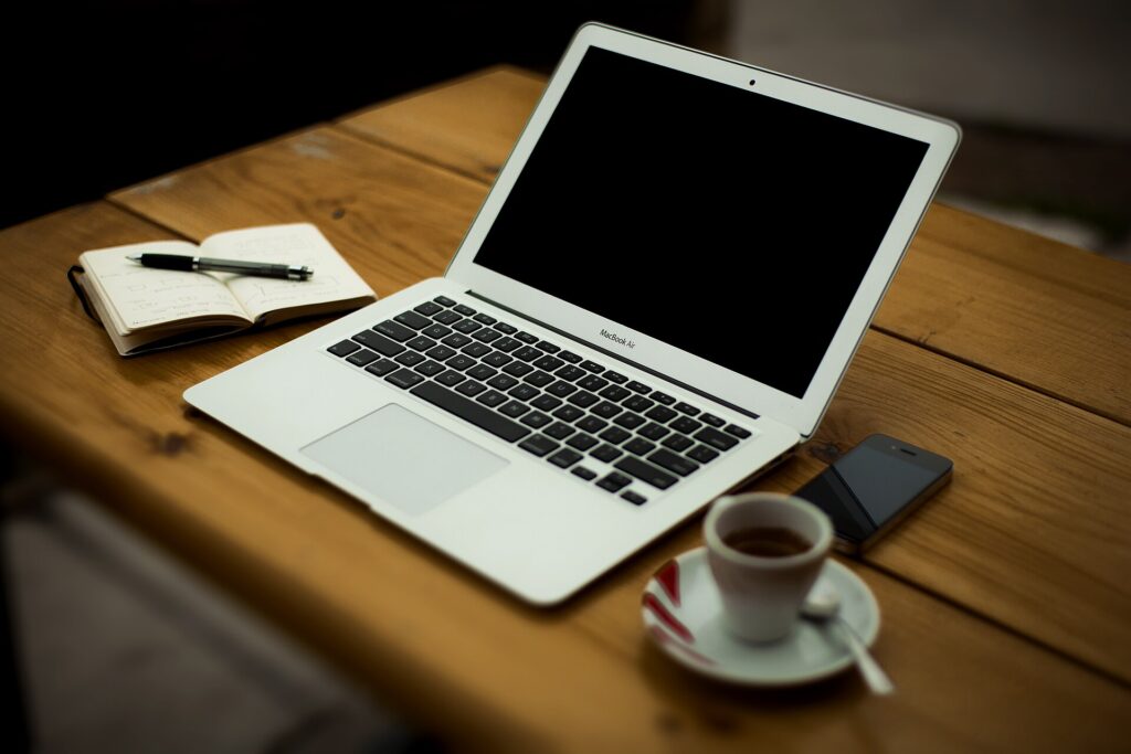 Tidy home office wifi UK 2026 setup with laptop, phone and notebook on a wooden desk