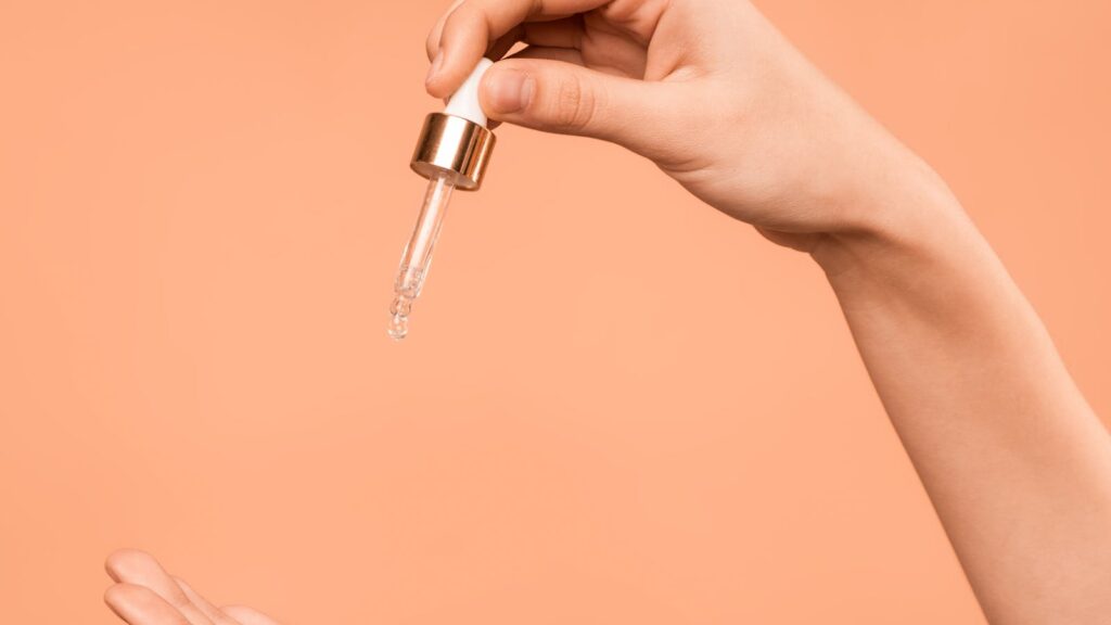 Glass dropper bottle of mandelic acid UK skincare serum on a neutral background