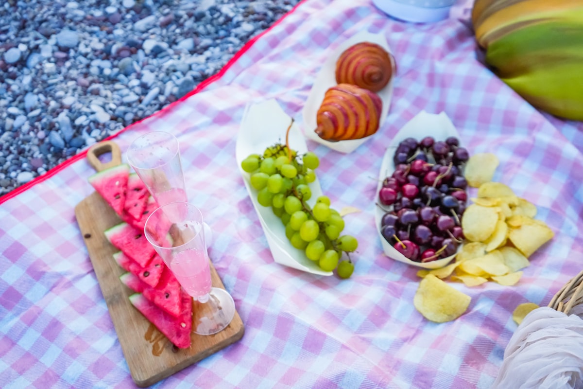 Picnic food ideas with fruit and pastries on a blanket