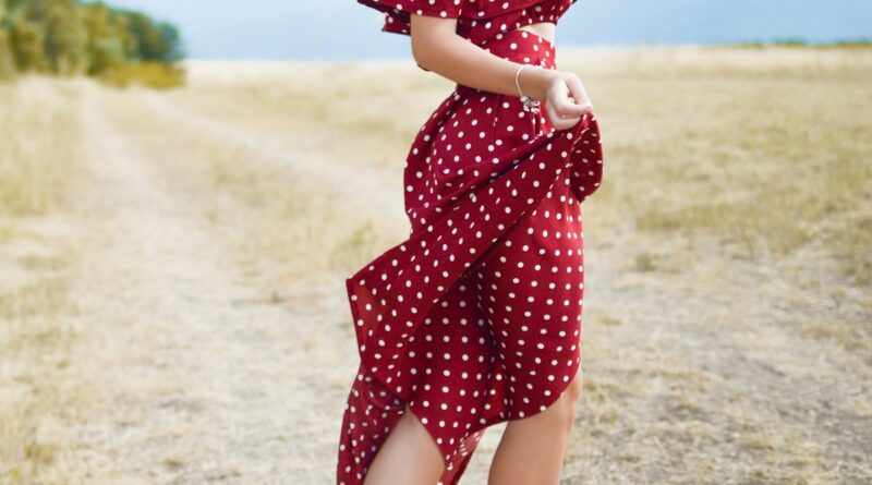 Woman wearing a red polka dot dress in a field - best polka dot dresses spring 2026