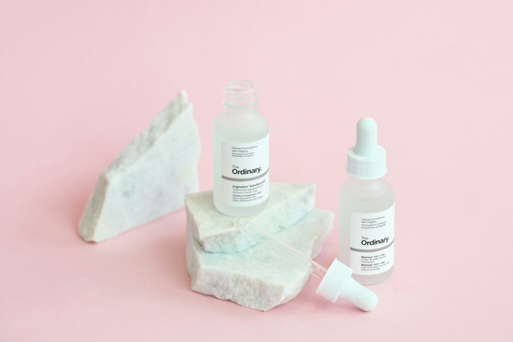 Skincare bottles arranged on a marble surface representing salicylic acid for blackheads products