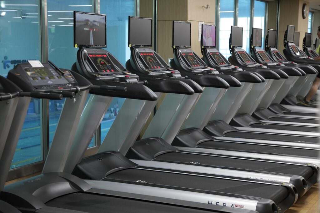 A row of treadmills in a clean light-filled space, illustrating the kind of equipment many UK home workers are now scaling down into a walking pad uk 2026 setup.