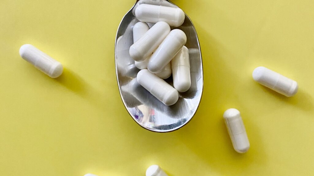 Astaxanthin for skin UK: red-pink antioxidant supplement capsules on a kitchen surface.