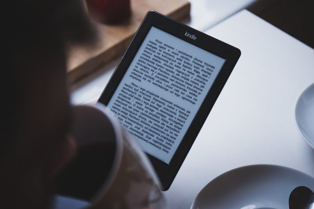 A reader using one of the best e-readers UK 2026 has to offer, holding the device in two hands while reading
