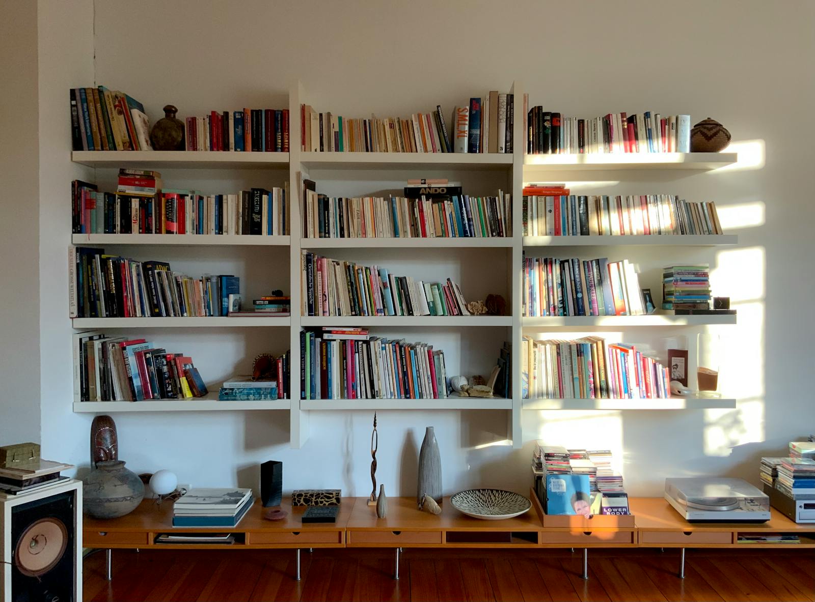 A collected living room with varied lamp bases and shelving - the layered look the no big light trend aims for