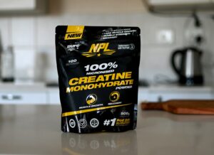 A tub of creatine monohydrate powder on a kitchen counter, illustrating creatine for women.