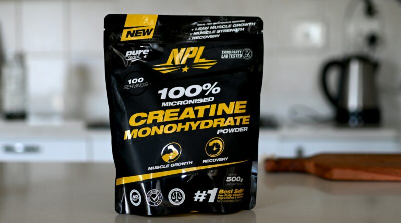 A tub of creatine monohydrate powder on a kitchen counter, illustrating creatine for women.