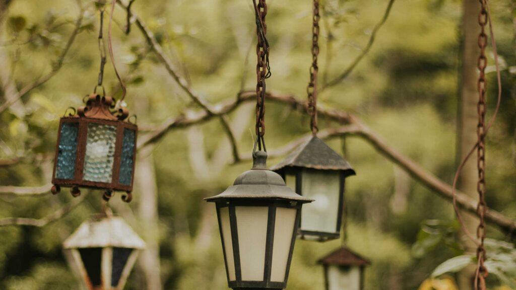 Vintage lanterns glowing in a lush garden at dusk - garden solar lights uk