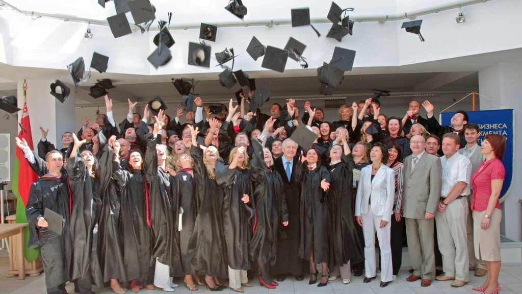 Graduates in caps and gowns celebrating at a UK ceremony, illustrating graduation outfits UK families plan for.