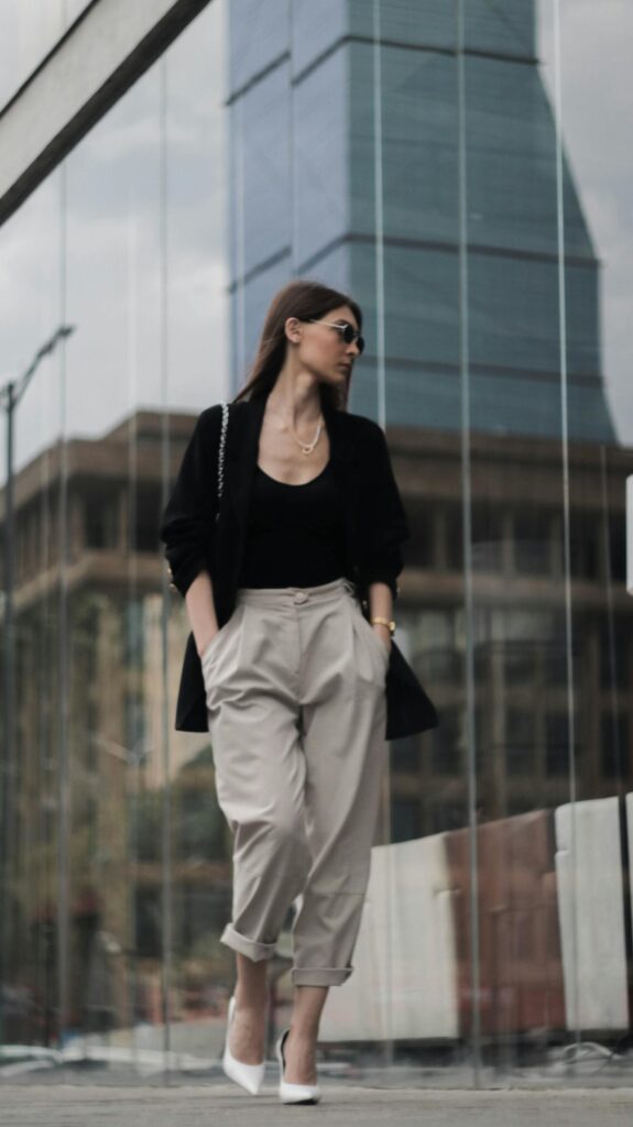 Stylish woman in summer workwear walking past a modern UK office building, illustrating hot office outfits UK 2026.
