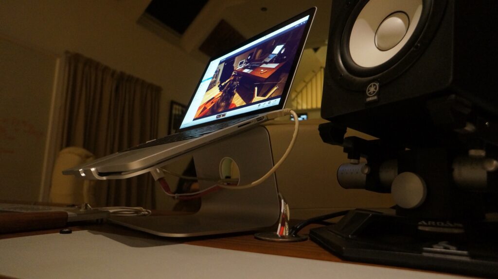 A laptop on a stand on a tidy desk, illustrating laptop stand UK ergonomic setup for home workers.