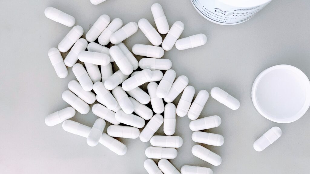 White supplement capsules representing myo-inositol for PCOS, taken twice daily by UK women managing the condition in 2026.