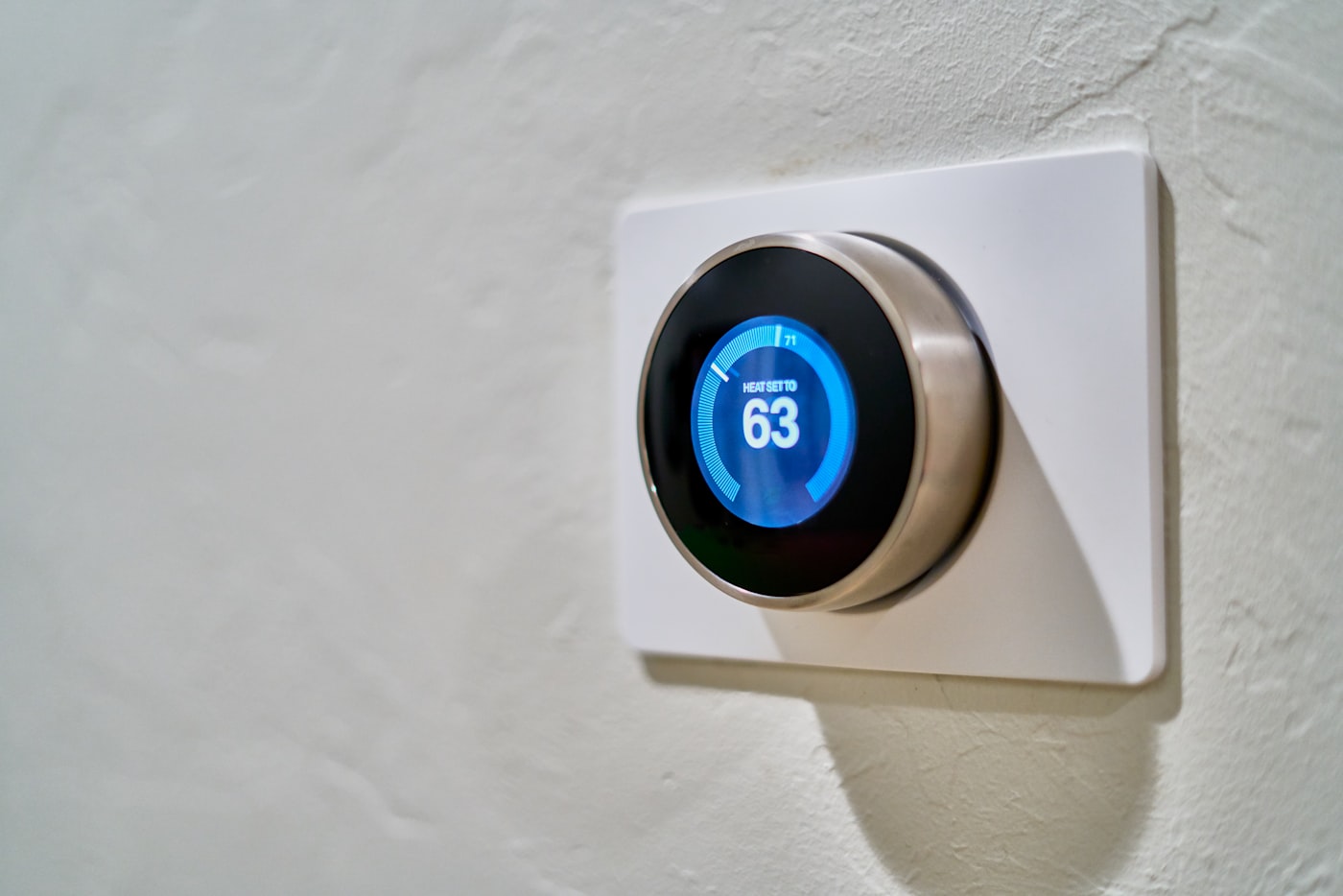 Smart thermostat on a UK flat wall showing temperature control
