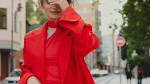 Woman wearing a head-to-toe tomato red 2026 outfit on a sunlit urban street