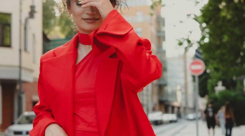 Woman wearing a head-to-toe tomato red 2026 outfit on a sunlit urban street