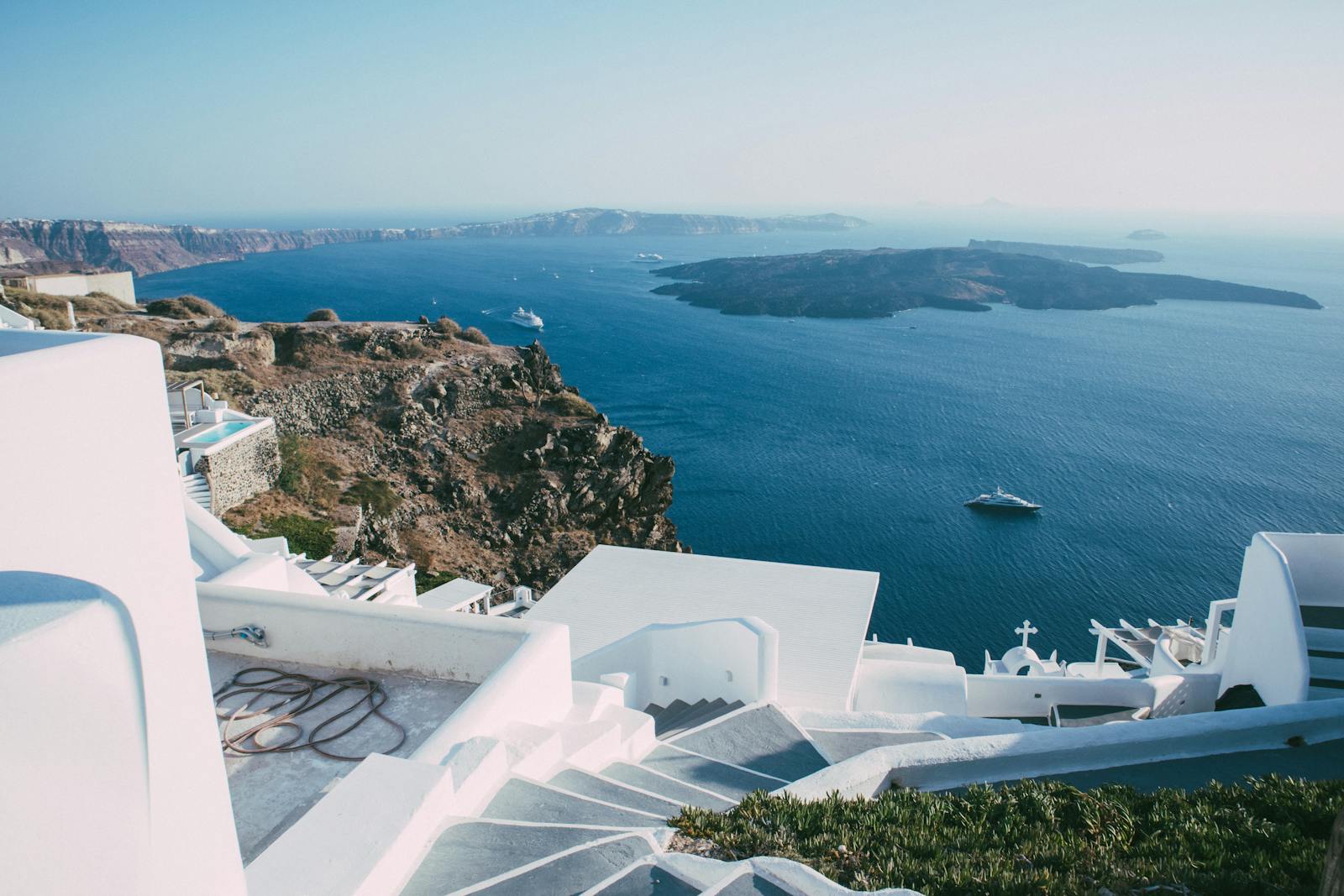 Traditional whitewashed buildings on a Greek island overlooking the sea, the visual register the Two Weeks in August review keeps returning to
