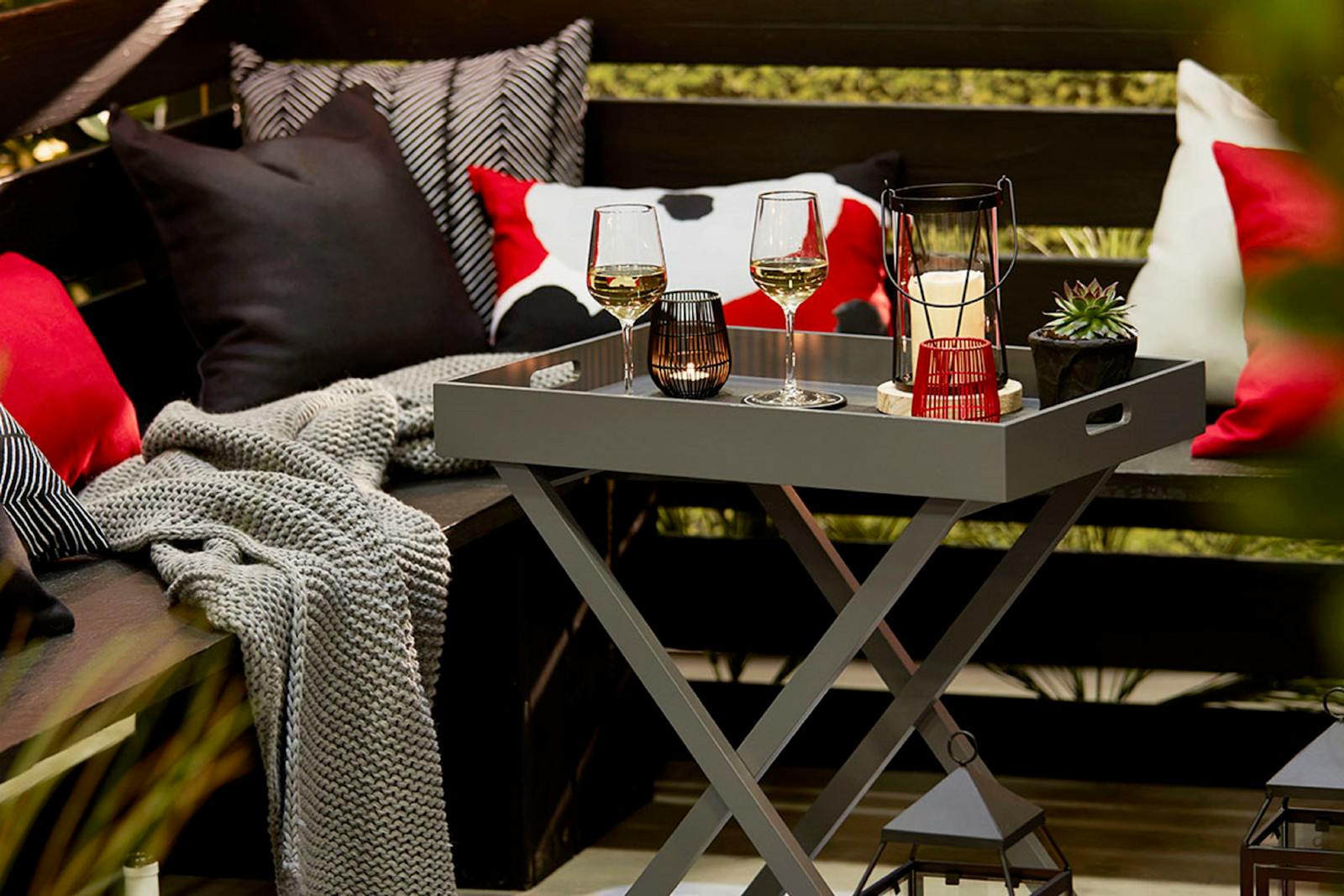 A long outdoor dinner table set with wine glasses and Mediterranean food, the central setting of many Two Weeks in August scenes
