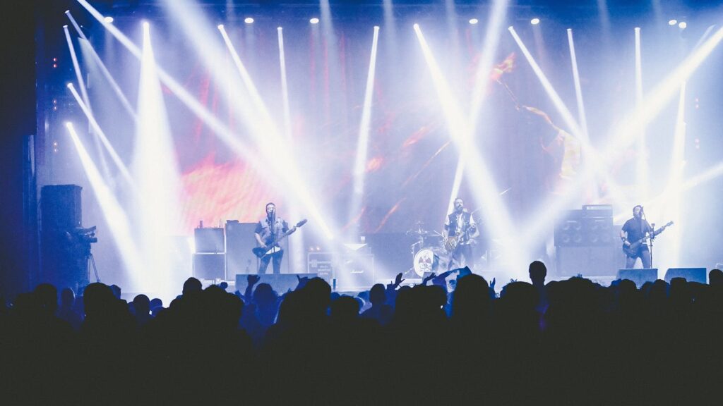 A live band performing on a small stage under spotlights, illustrating why UK music venues are closing in 2026.