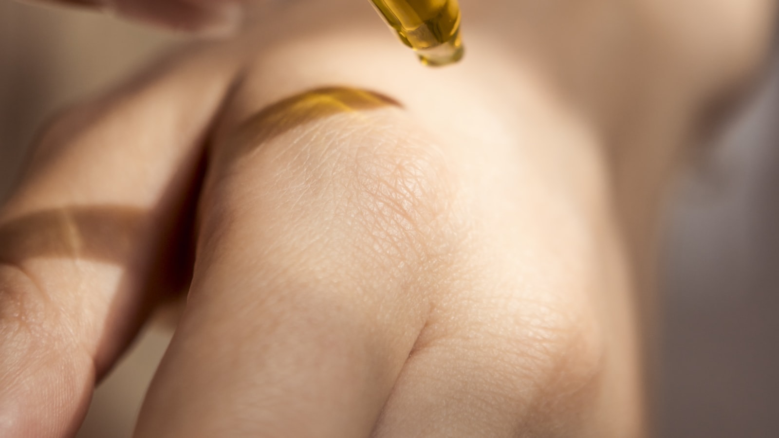 Hand applying a skincare serum, much like using azelaic acid for rosacea