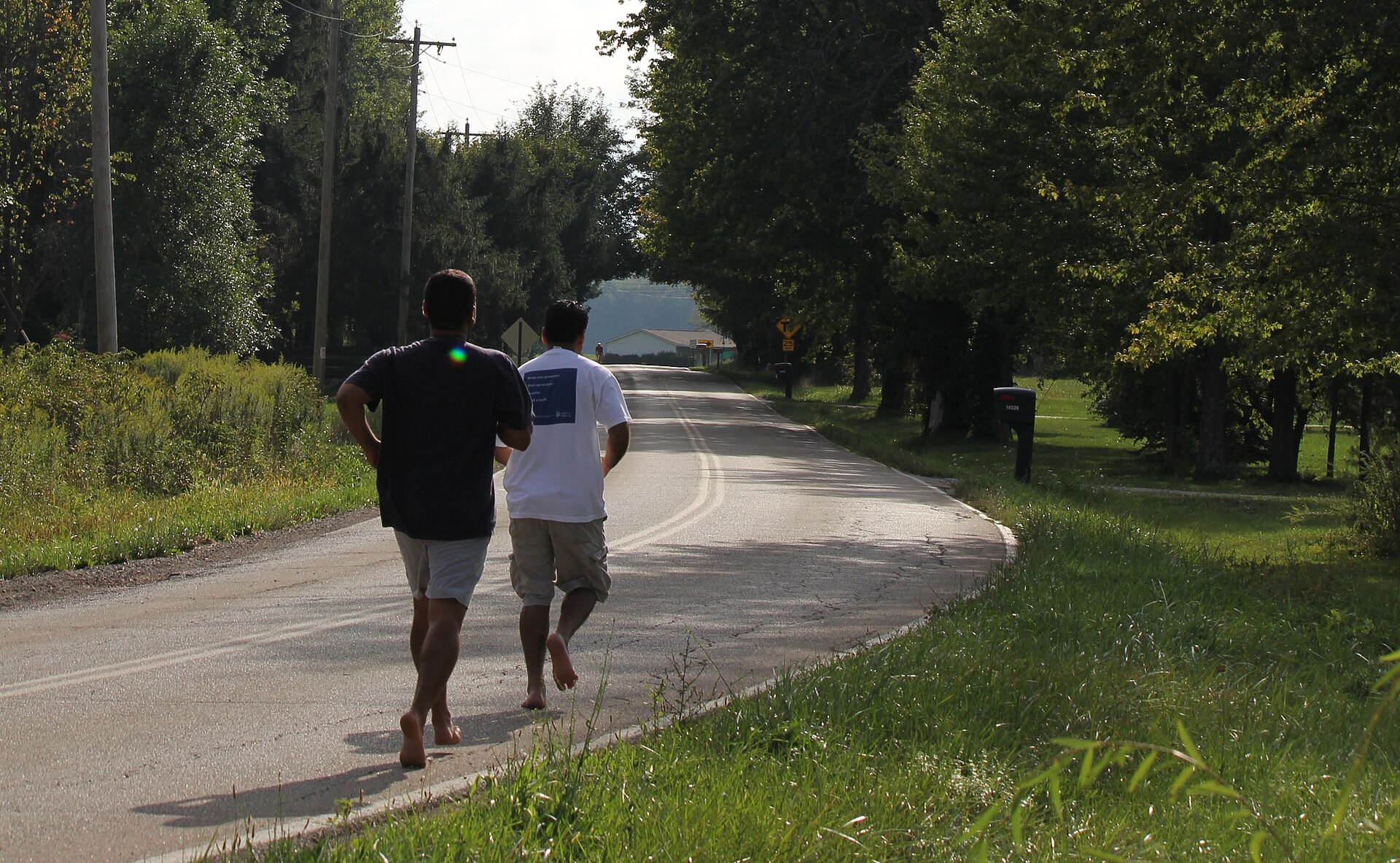 A runner on a path mid-stride, the forefoot landing barefoot shoes tend to encourage