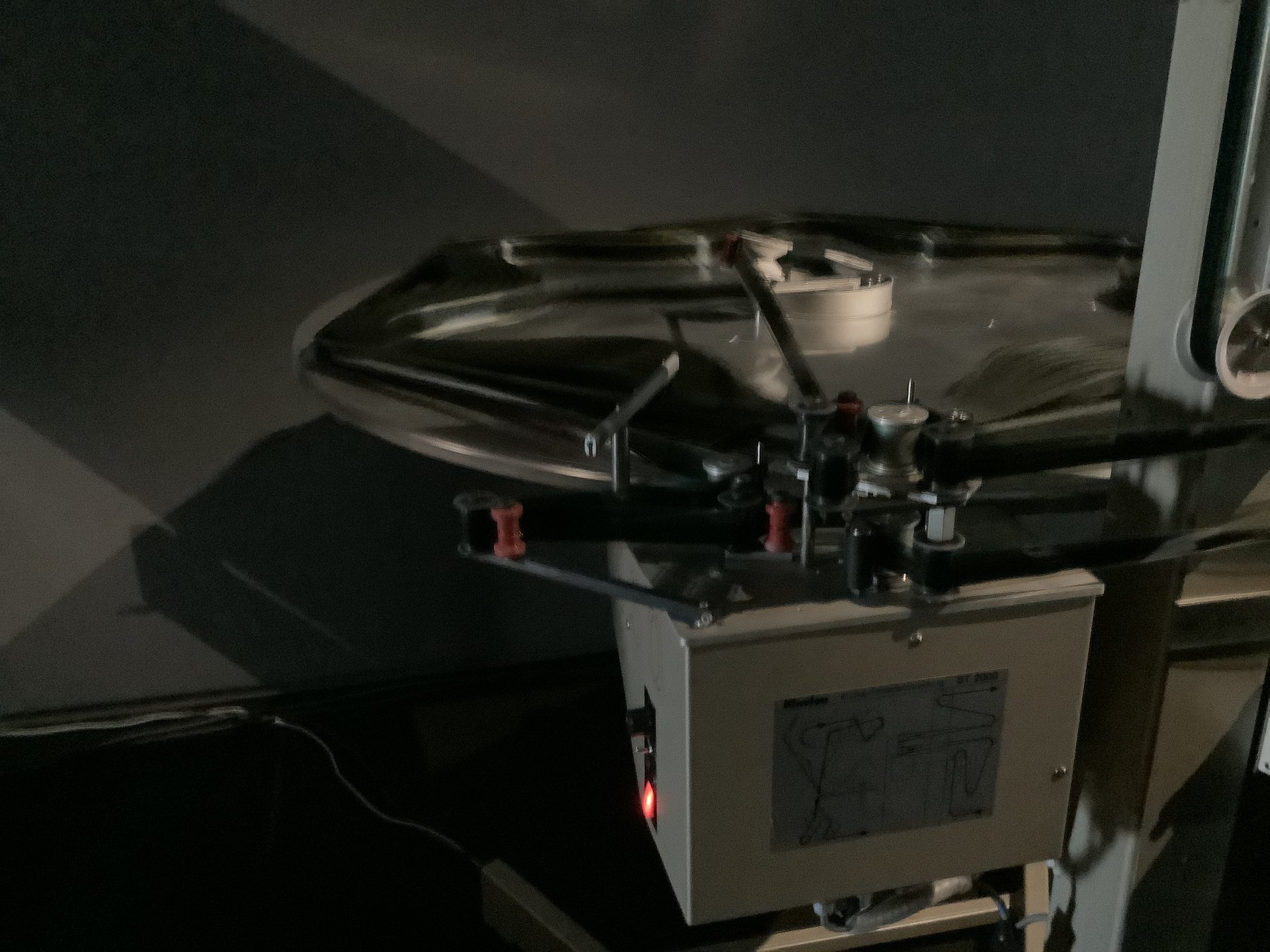 A 70mm film reel mounted on a cinema projector in a projection booth