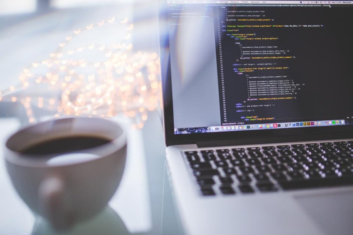 A laptop and coffee on a desk, the kind of focused workspace a garden room office provides