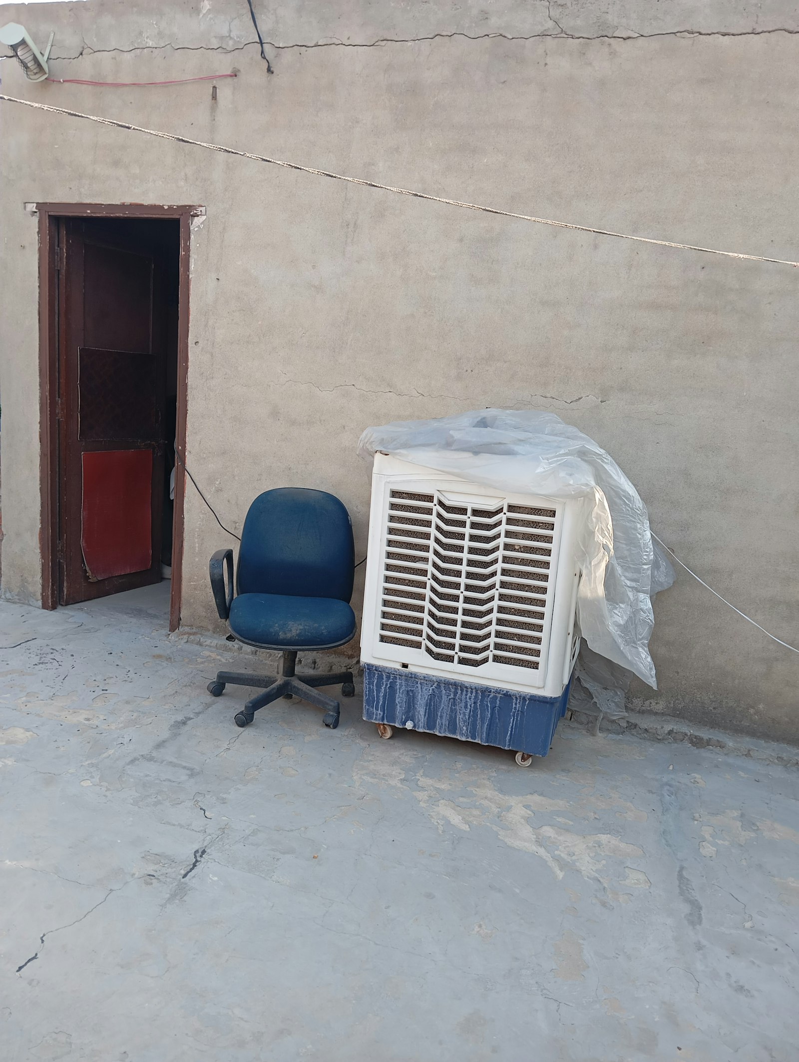 Portable air conditioning unit set up beside a chair in a home office