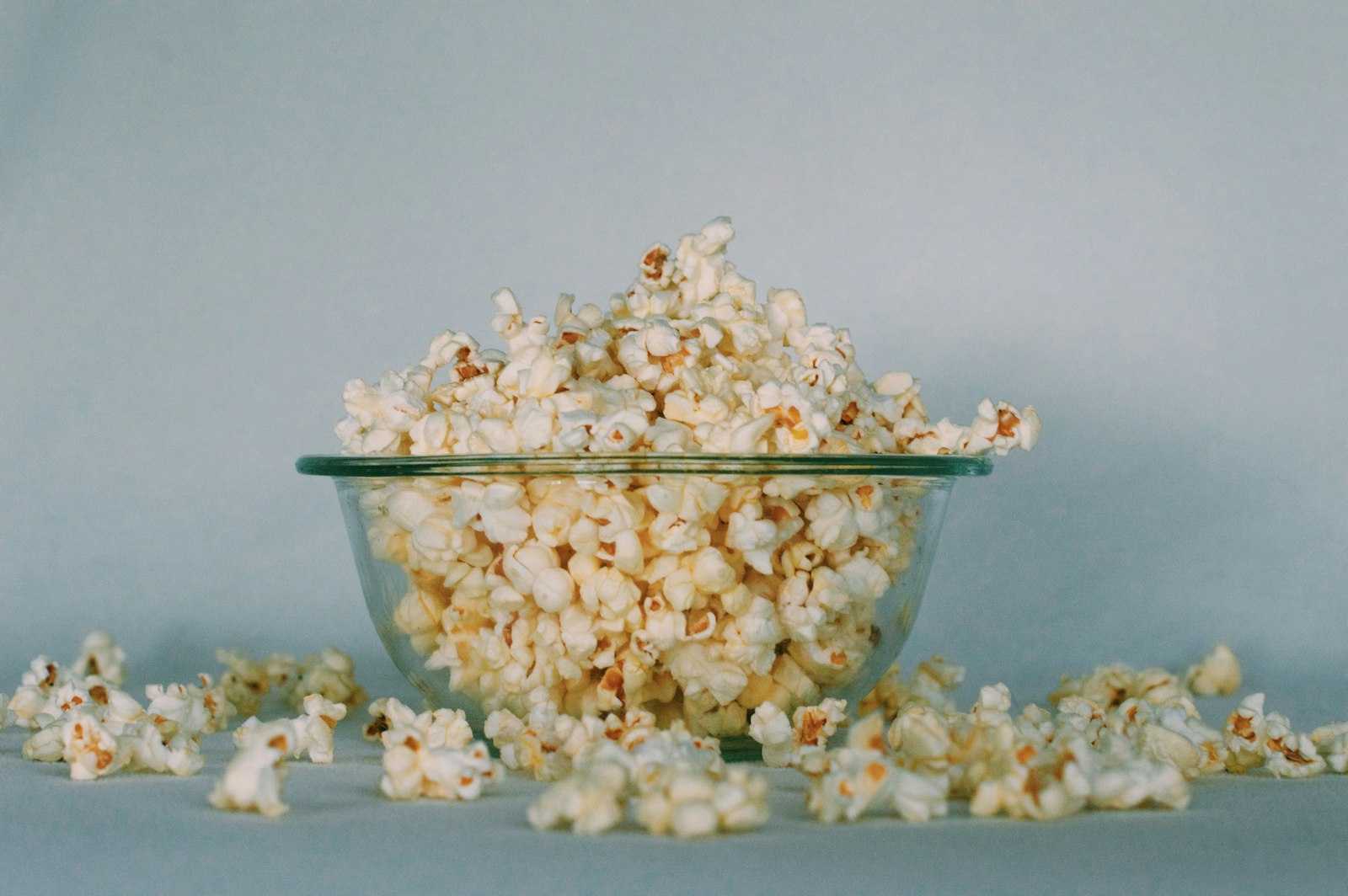 A bowl of cinema popcorn against a blue background