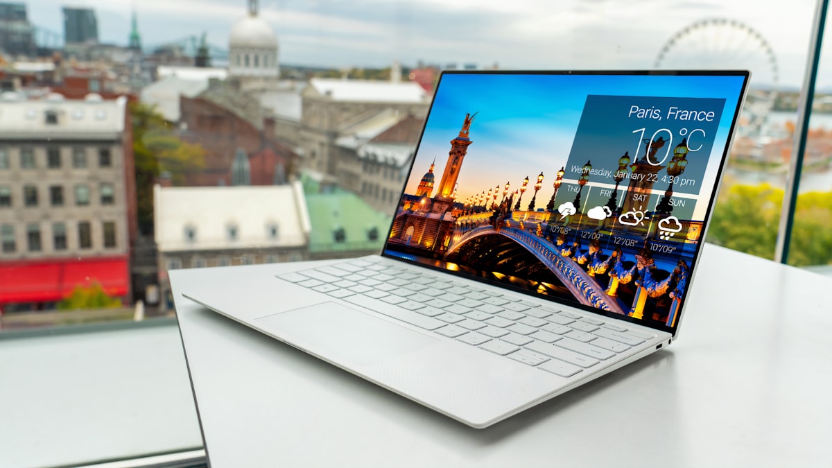 Slim laptop set up for hybrid working with a city view behind it