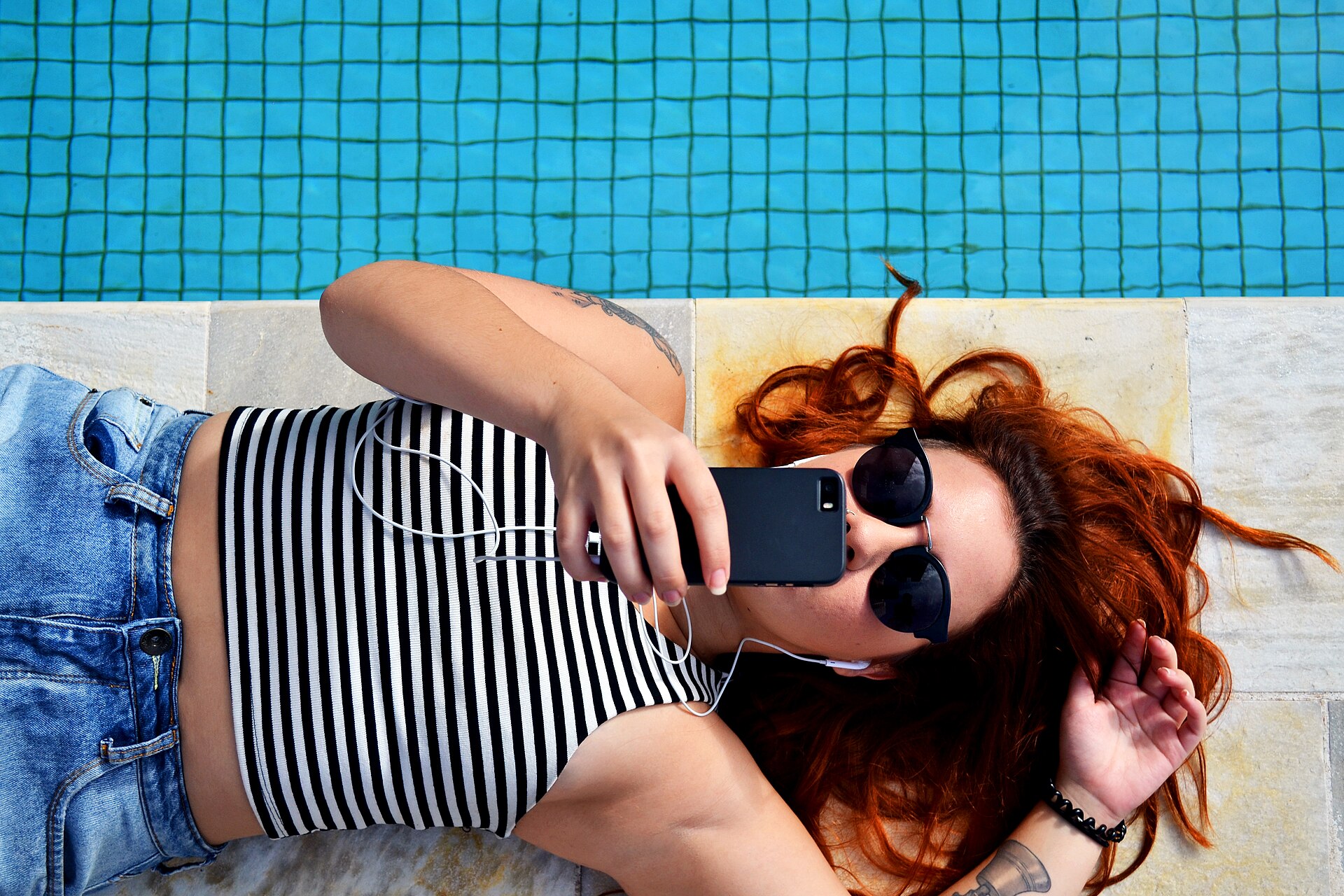Woman listening to an audiobook through earphones on her phone