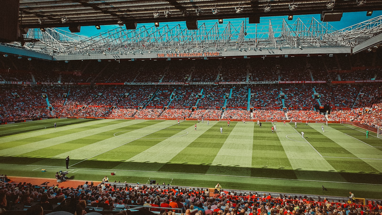 Football fans watching an evening game in a packed stand