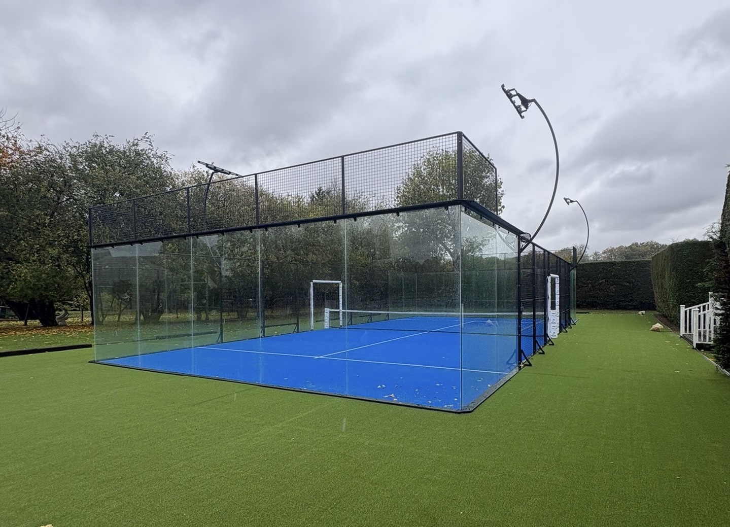 An enclosed glass-walled padel court of the type spreading across the UK