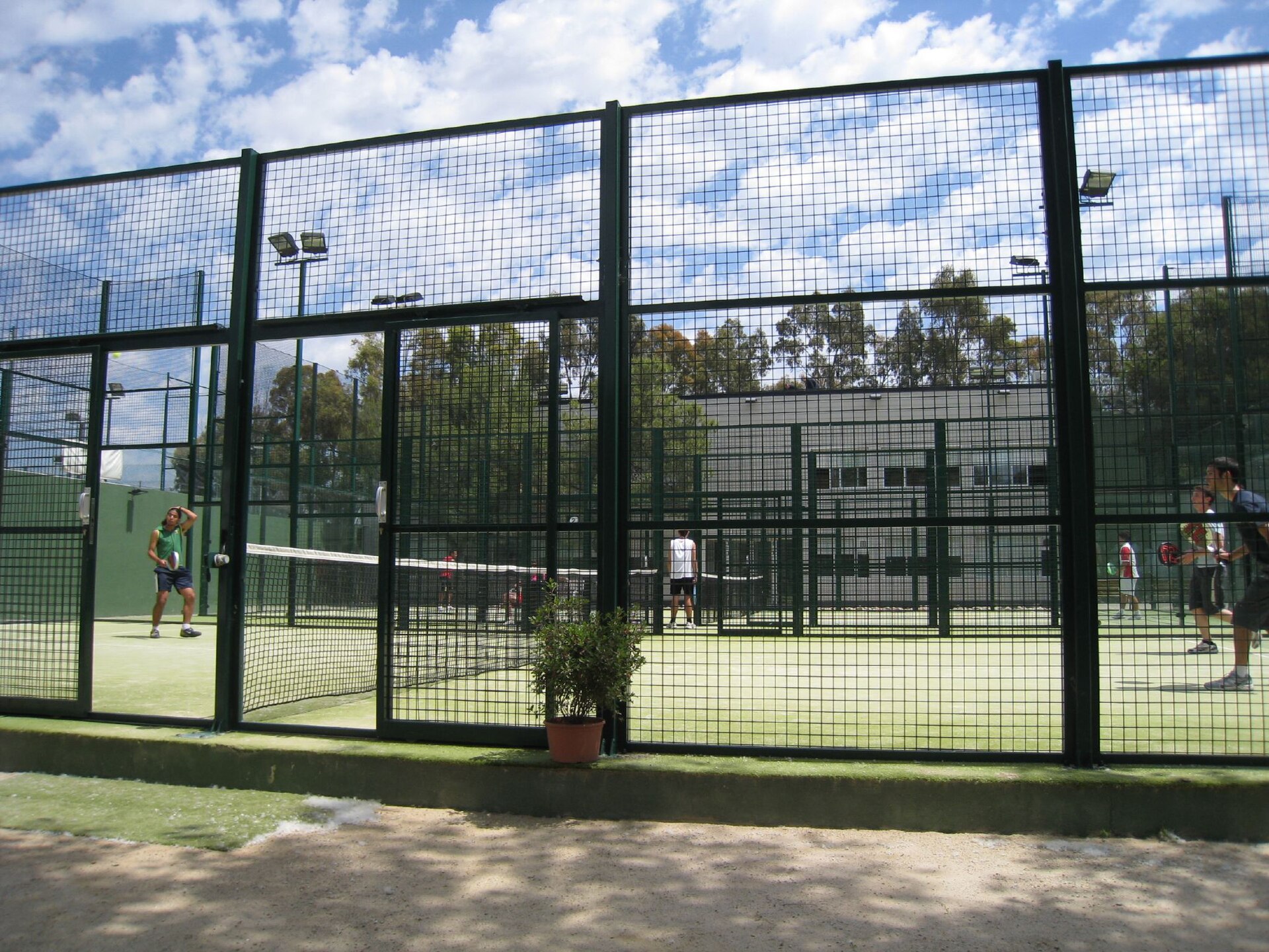 Four players in a doubles padel game, the sport's standard social format