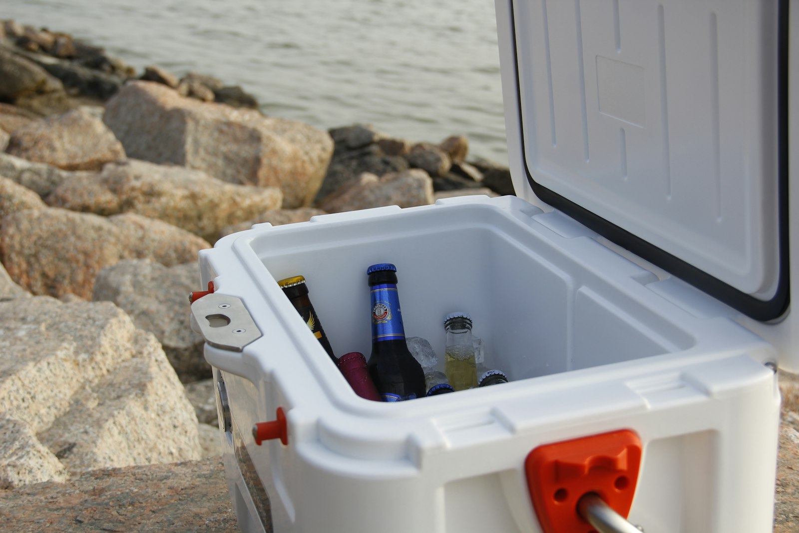Chilled drink bottles packed in ice inside the best cool box for camping