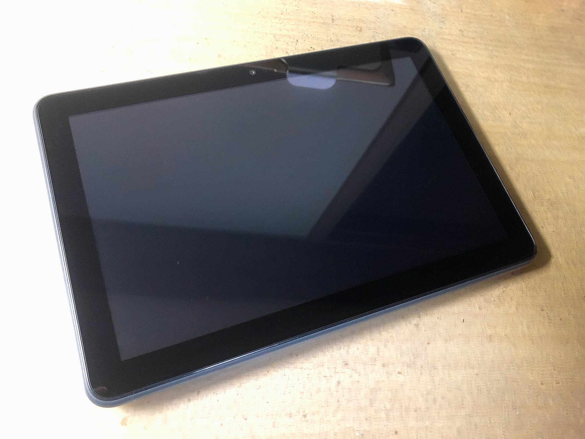 Amazon Fire HD tablet lying on a wooden table with the screen off