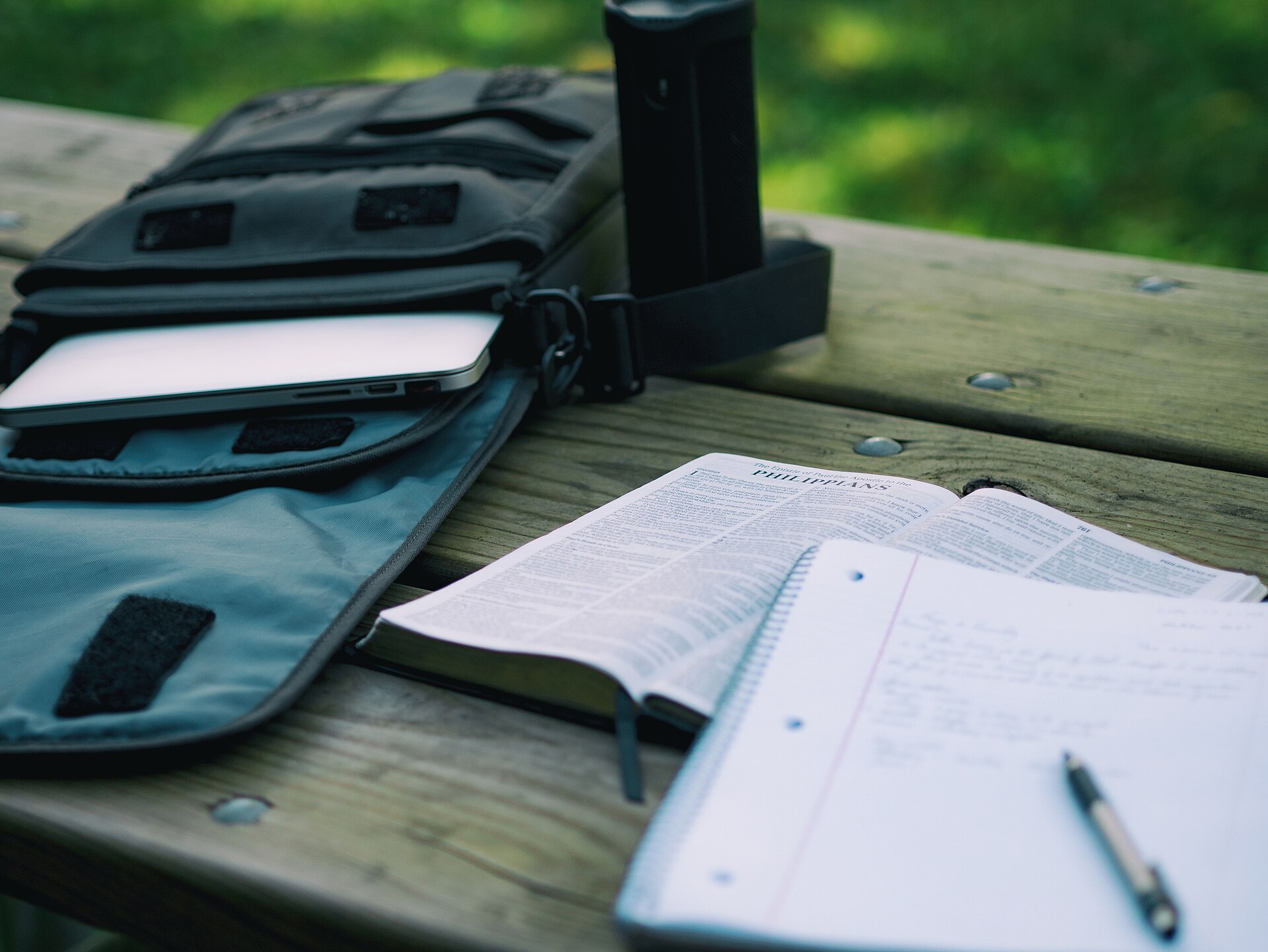 Student homework spread across a desk beside a laptop