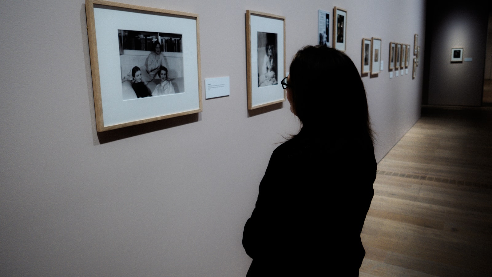Woman viewing framed artwork in a quiet gallery room