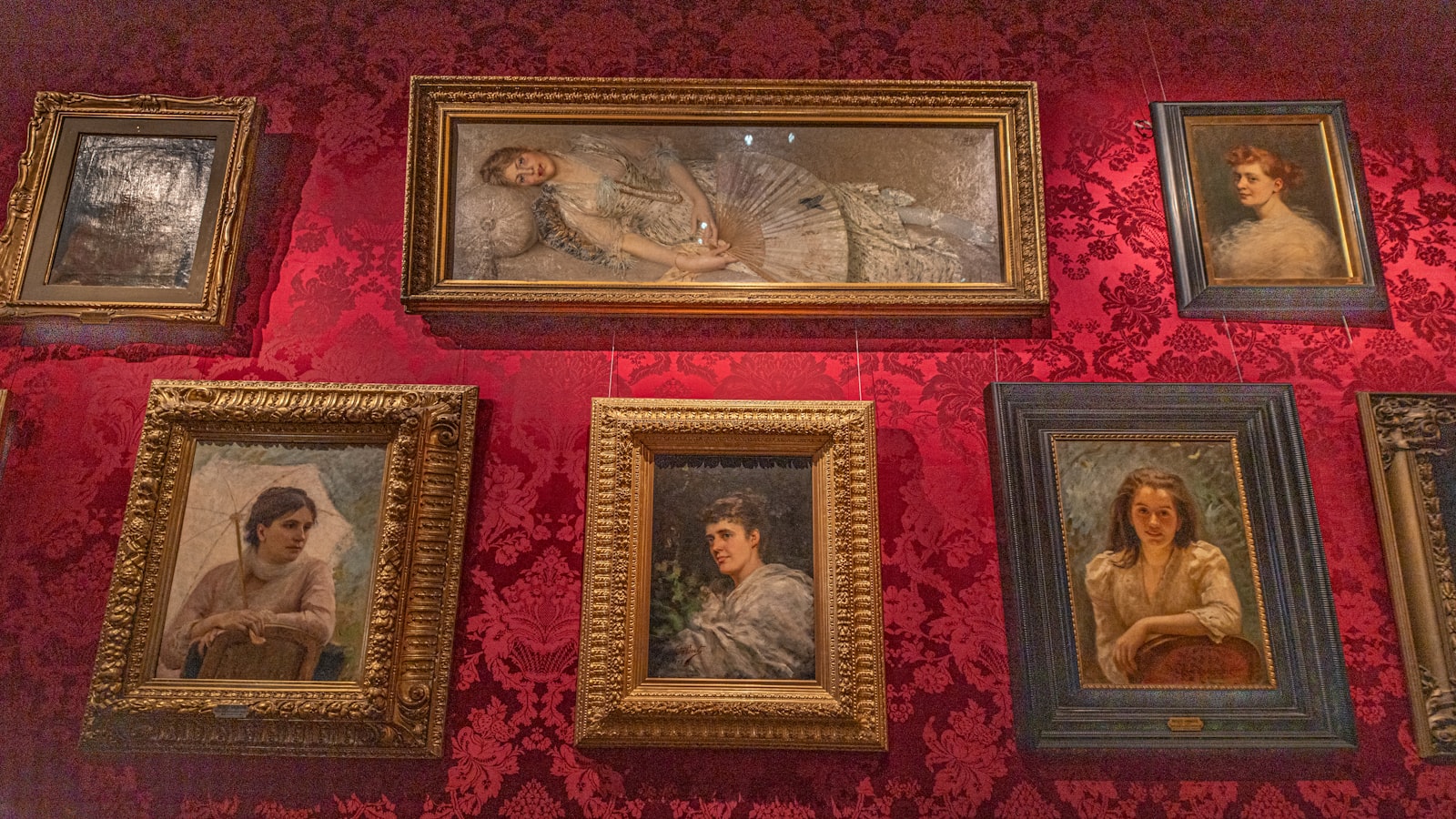 Salon-style wall of framed paintings hung close together, Royal Academy style