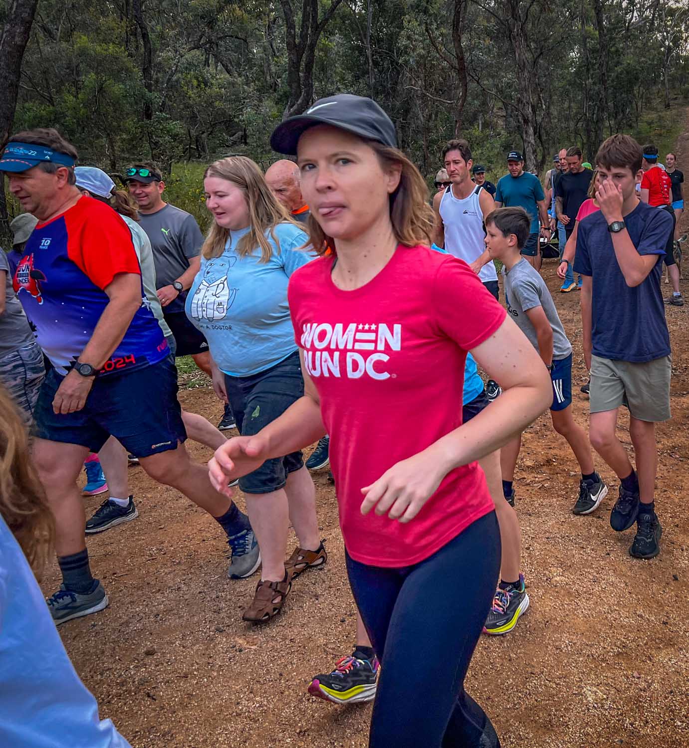 Parkrun runners mid-course on a tree-lined path
