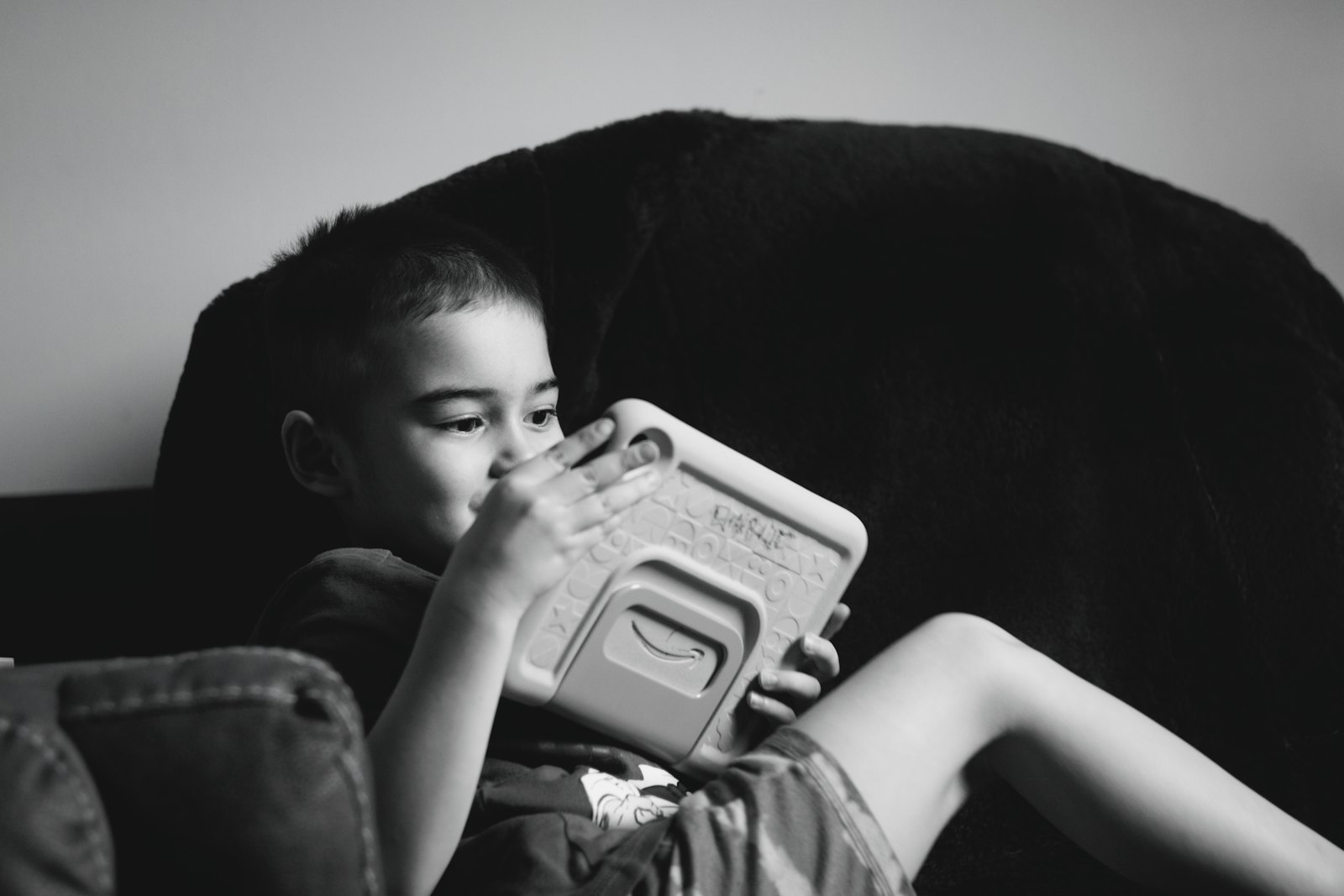 Choosing the best tablet for kids in the UK: a young boy absorbed in a tablet
