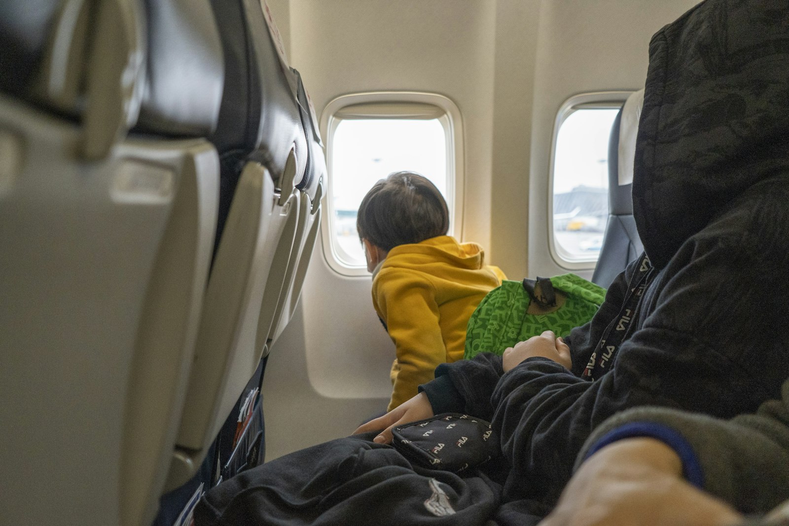 Small child in an airplane seat, where a loaded tablet earns its keep
