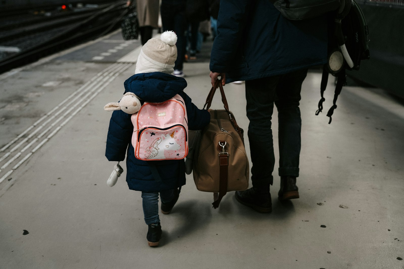 Child walking through the airport with family luggage at the start of the summer holidays