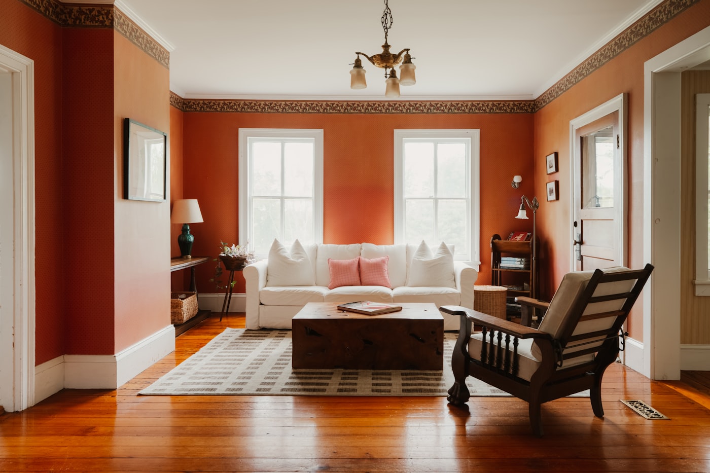 Warm orange drenched living room with white sofa and wooden table